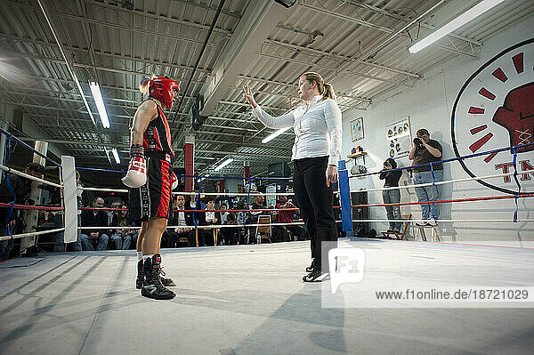 A female referee gives a standing eight count to a female boxer during a boxing match  Toronto  Ontario.