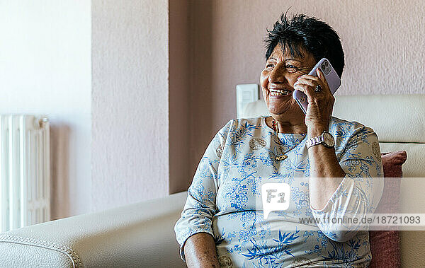 latin american senior woman talking with her friends on the smartphone
