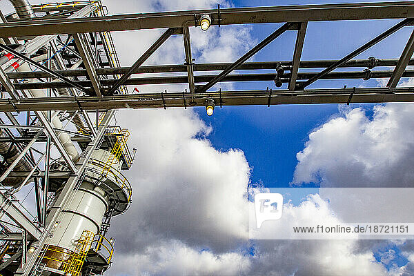 Pipe rack and tower in a refinery against blue skies