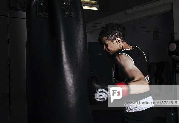 Young man boxer practicing a hit boxing during workout.