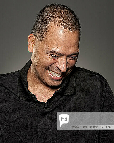 Studio portrait of 47 year old African American man laughing.