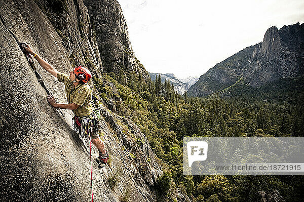 A climber reaches to place gear in Yosemite  June 2010.