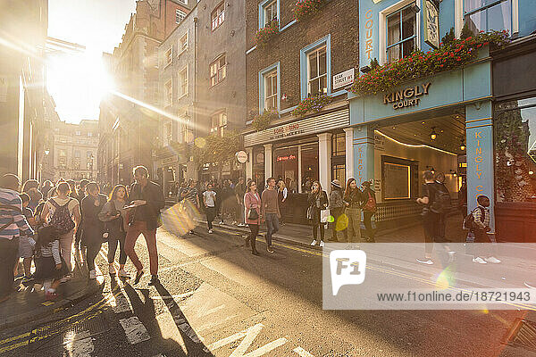 Brewer street with sun shining and crowds of tourists
