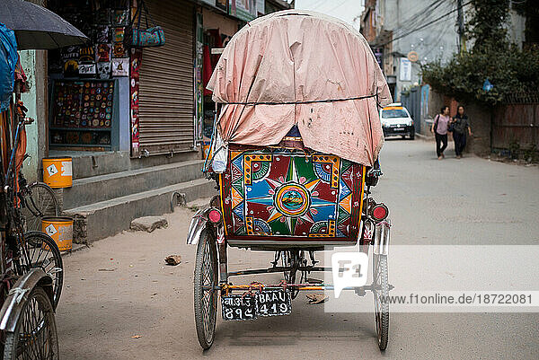 Rear end of colorful bicycle taxi on street