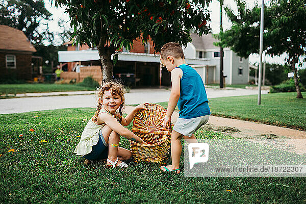 Young girl smiling with basket full of peaches in front yard
