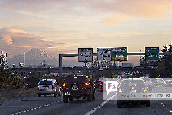 Heavy traffic stalls interstate 5 as Mount Rainier looms in the background at sunset in Seattle  Washington.