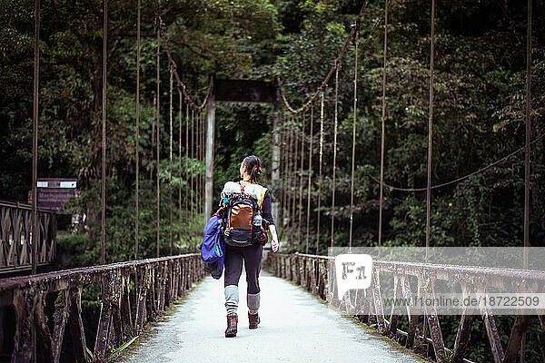 Androgynous woman walks across wire bridge to Machu Picchu