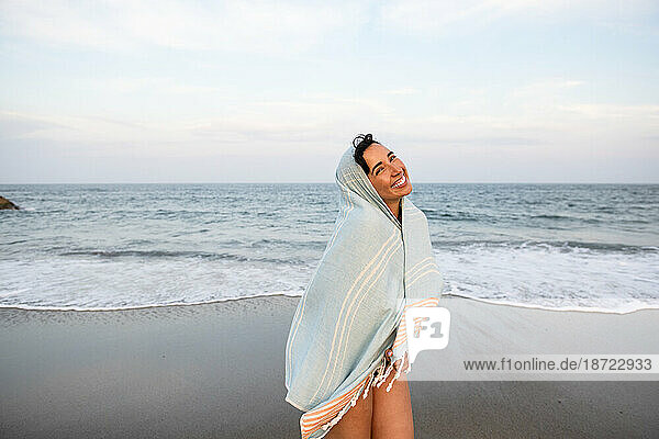 Latina woman having fun at the beach with towel