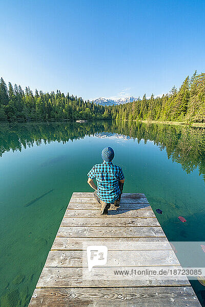 Rear view of man on pier looking at Crestasee lake  Switzerland