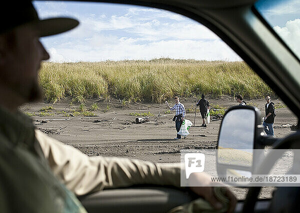 Oregon State Park Ranger gets a wave from clean-up volunteers at the coast on Ft Stevens State Beach  Oregon.