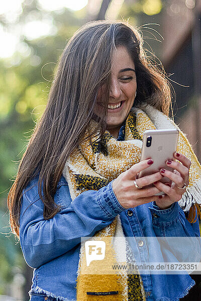 Happy young woman using phone