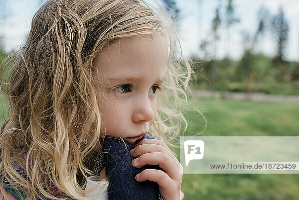 portrait of a girl thinking whilst playing outside