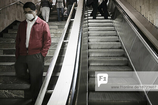 A man wearing a mask in the stairway of the subway (metro) station during the swine flu epidemic in Mexico City  DF  Mexico.