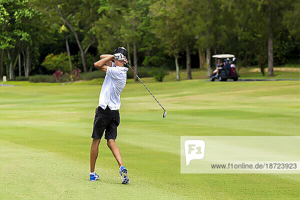 Rear view of young man playing golf
