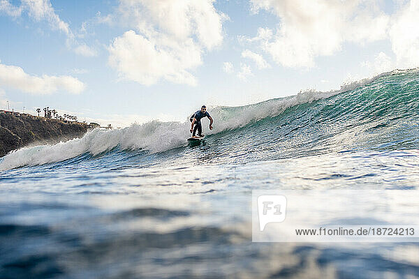 Surfer on a wave against a clear sky in Tenerife
