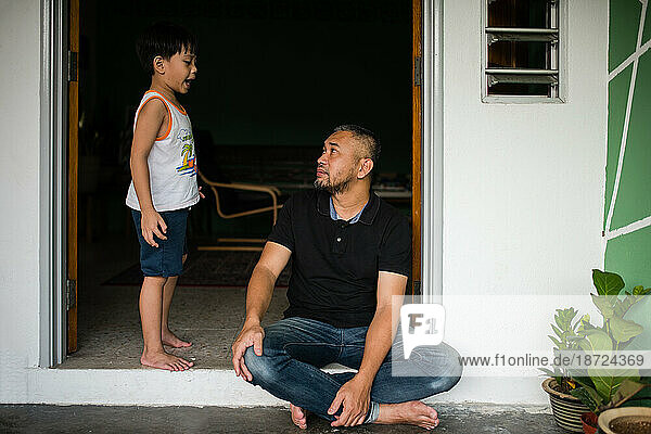 Boy talking to father at the front door