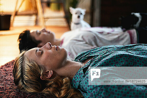 portrait of couple relaxing in meditation at home on floor