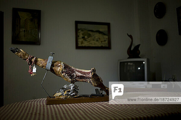 A cured Pata Negra ham leg  known as Bellota ham  sits on a dinning room table .