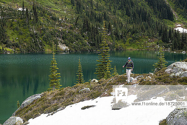 Full length view of women hiking by an alpine mountain lake in Canada.
