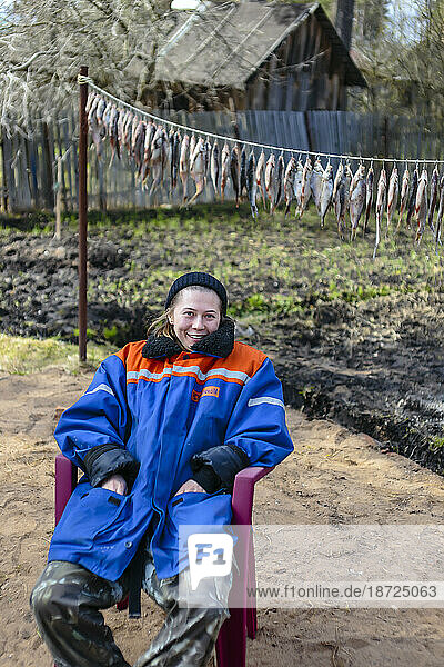 Portrait of blonde woman sitting on chair in winter coat  Tikhvin  Saint Petersburg  Russia