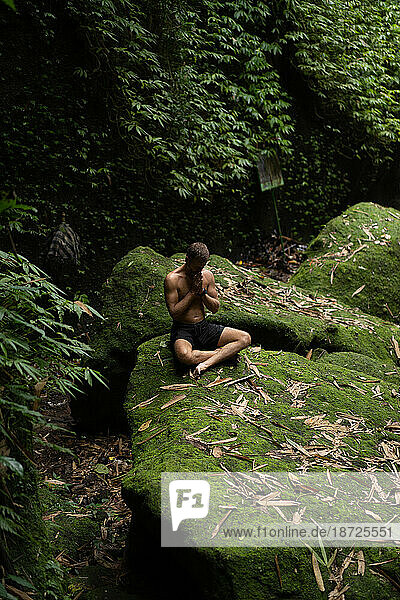Man meditates in nature in the jungle. Breathing and balance.
