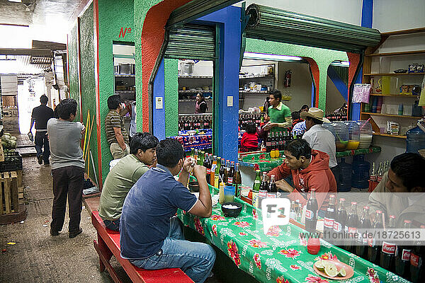 Young men sit down at a market eatery to eat lunch in San Cristobal de las Casas  Chiapas state  Mexico.