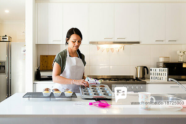 A woman baking cupcakes in her kitchen
