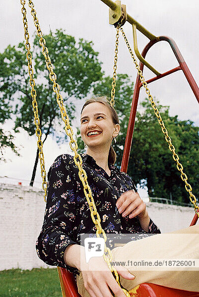happy woman smiling and riding a swing