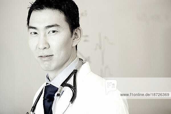 A portrait of a male doctor in a white lab coat with a stethoscope around his neck.