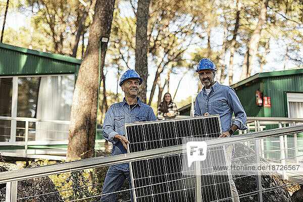 Photovoltaik-Techniker tragen Solarpanel zusammen