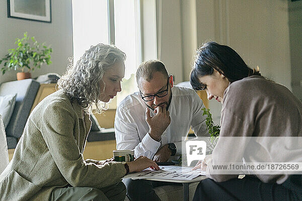 Businessman and businesswoman having a meeting with client in architect's office