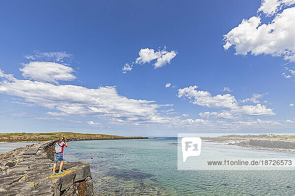 Australien  Victoria  Port Fairy  Touristin beim Fotografieren im Port Fairy Coastline Protection Reserve