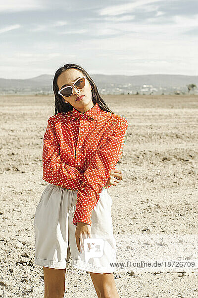 Young fashionable woman wearing sunglasses in desert