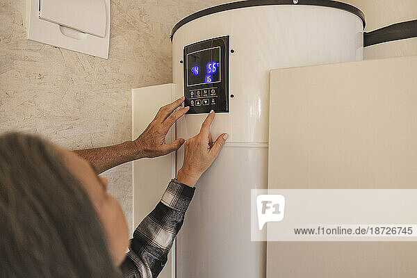 Man and woman adjusting smart home thermostat