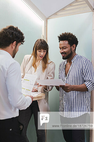 Business colleagues discussing document in office