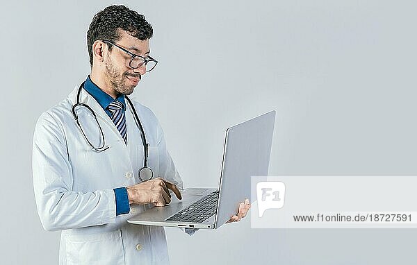 Hübscher Arzt mit Laptop isoliert. Junger Arzt mit Brille mit Notebook auf isolierten Hintergrund  Lächelnde Arzt stehend mit Laptop isoliert