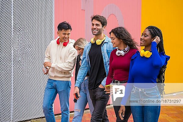 Gruppe multiethnischer Freunde  die auf dem Universitätscampus spazieren gehen und Spaß haben  junges Millennial-Handy-Technologiekonzept