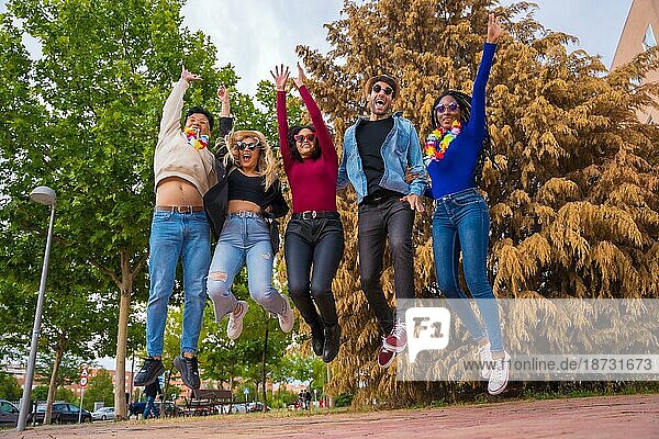 Eine Gruppe multiethnischer Freunde feiert eine Party in einem Park  Verschiedene junge Leute springen vor Freude in einem Sommerparty-Portrait  Happy Hour  Mittagspause und Jugendkonzept