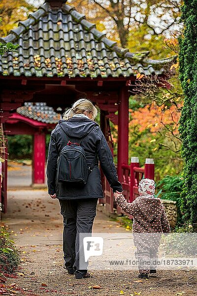 Ein kleines Kind und eine Frau gehen im Park spazieren