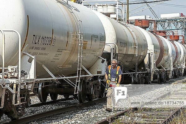 Detroit  Michigan  Chemietankwagen der Eisenbahn in der Nähe des Stadtzentrums von Detroit. Ein Arbeiter  der eine Fernsteuerungsweste trägt  steuert die Bewegung des Zuges  während er neben den Gleisen entlangläuft