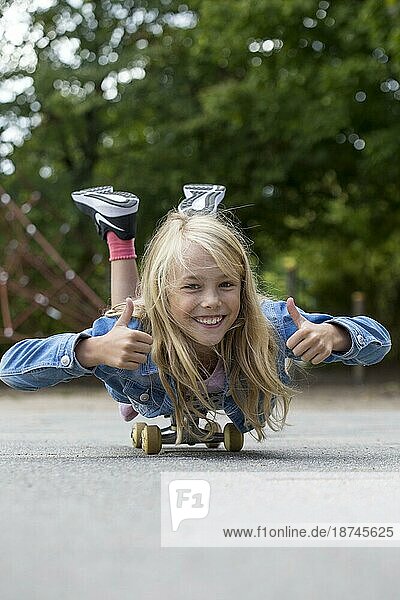 Mädchen (10) liegt auf Skateboard  Kiel  Schleswig-Holstein  Deutschland  Europa