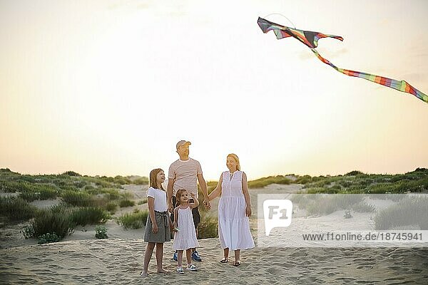 Glückliche Familie mit Eltern und Kinder spielen zusammen mit Schlangen auf einem Strand Urlaub. Sommer Glück Konzept mit Mixed race Menschen  die Spaß am Meer