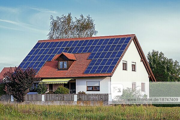 Modernes Haus mit Solarzellen auf dem Dach. Haus und Umgebung mit Photoshop verändert