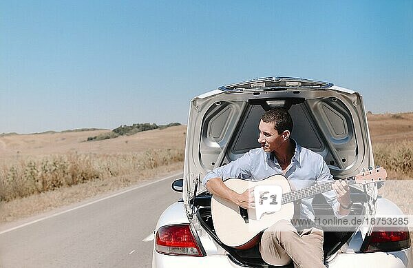 Junge genießen die Freiheit während der Fahrt im Cabrio durch Wüste grasbewachsenen Landschaft im Sommer Tag