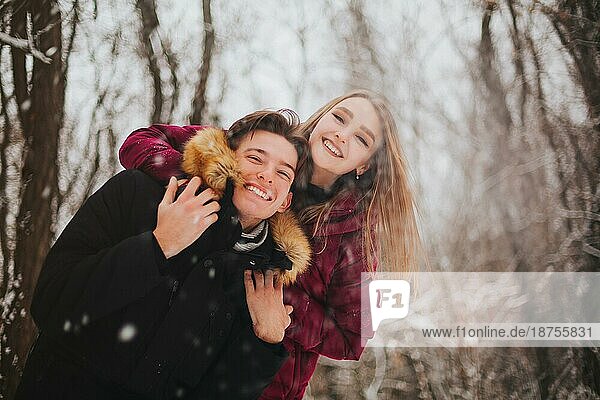 Schönes junges Teenagerpaar verbringt Zeit zusammen draußen im kalten Winter. Glückliche und fröhliche Menschen
