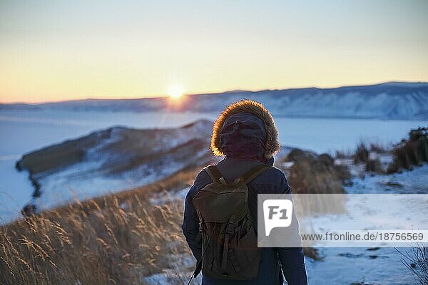 Junger Mann steht im Winter gefrorenen Natur und beobachten ruhigen Winter nebligen Sonnenuntergang. Thinking Konzept  volle Freiheit Foto  schöne Landschaft. Ogoy Insel  Baikalsee  Sibirien  Russland  Europa