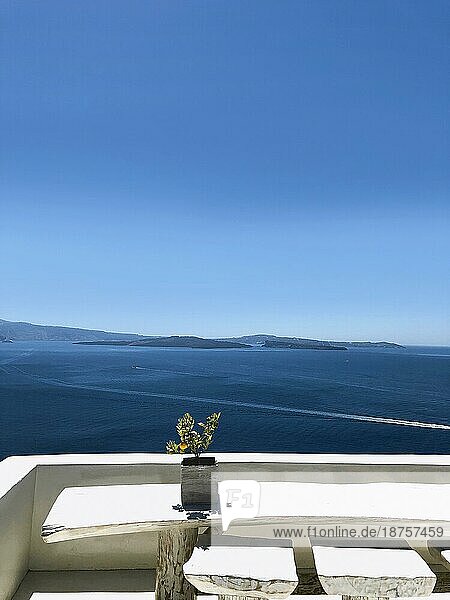Malerischer Blick von der Terrasse auf das ruhige blaue Meer unter dem blaün wolkenlosen Himmel im Sommer