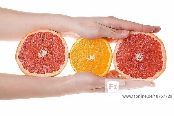 Weibliche Hände halten geschnittene Teile von Orangen und Grapefruits vor weißem Hintergrund