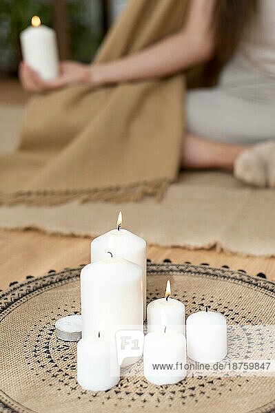 Frau meditiert mit Tablett mit Kerzen