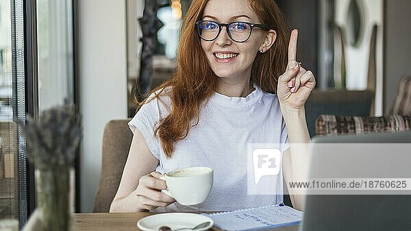 Frau mit Kaffeetasse und Fingerzeig